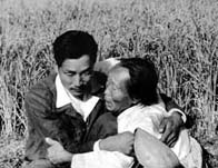 Korean civilians huddled together in a field