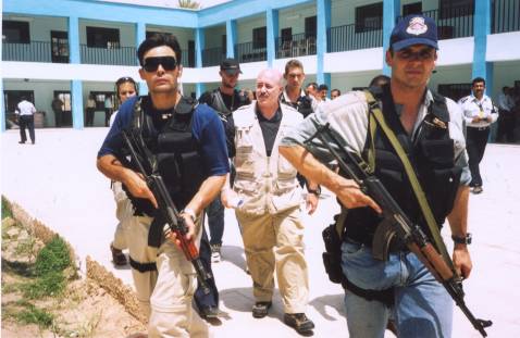 Kerik walks amidst a phalanx of bodyguards during visit to the Police Academy in Baghdad, July 2003.